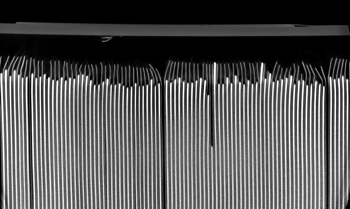 CT slice of a stacked prismatic cell showing electrode edges with bent and folded layers at the top of the stack